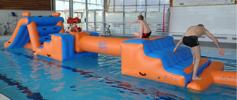 Adolescents qui s'amusent sur un parcours aquatique gonflable