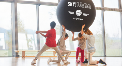 Enfants qui jouent au Kin-Ball avec un ballon géant